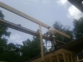 Carpenter setting a ridge beam over a new addition frame — Ice Dam Removal by Roofing Brothers in Concho