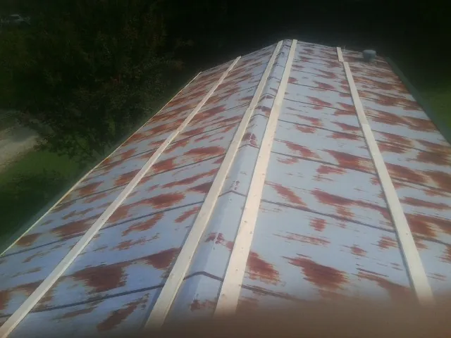 Rusted metal roof panels with new wood purlins before replacement — Storm Damage Roof Repair in Concho by Roofing Brothers
