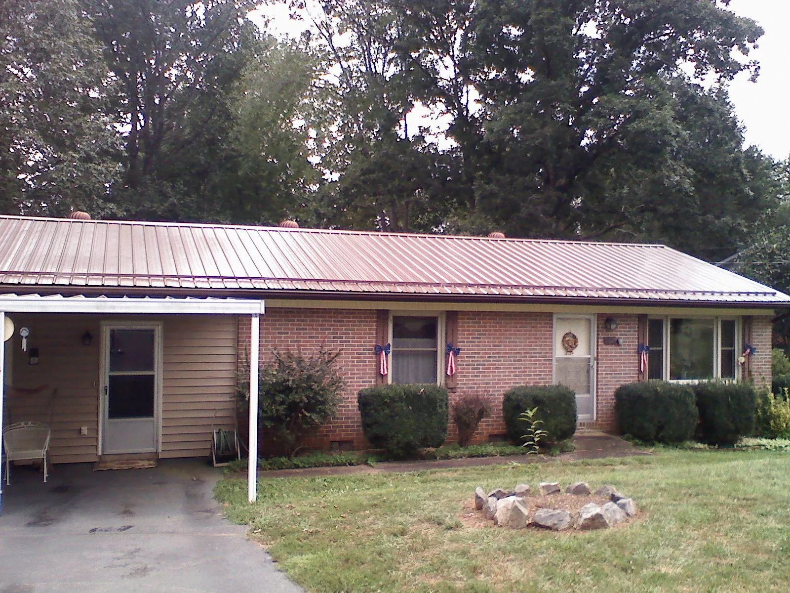 Bronze metal roof and carport on a brick ranch home — Roof Repair work by our crew in Concho